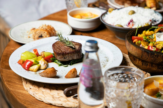 A gourmet steak dinner with side dishes and water